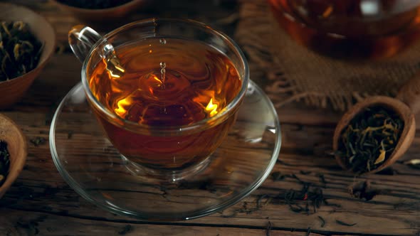 Super Slow Motion Shot of Droplet Falling Into Tea at 1000 Fps with Still Life Background