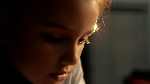 The girl is concentrating on the opponent's move during a chess game.