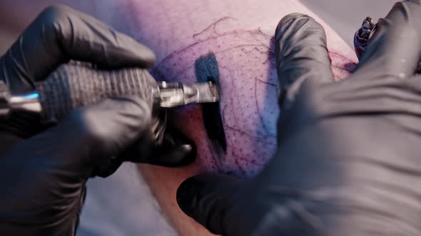 A Session in Tattoo Salon  Filling in the Tattoo with Black Color