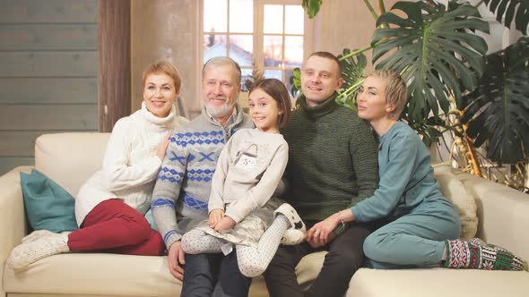 Happy Extended Family Sitting on Sofa Together