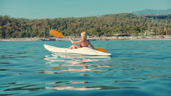 Paddling Canoe Adventure. Tourist Woman Spending Day Kayaking On Sea. Active Woman Having Fun.