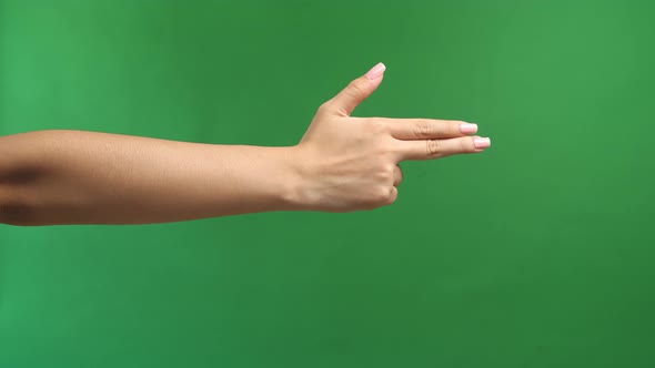 Woman's Hand Making Shooting Gun, Hand Pistol Gesture On Isolated On Green Screen Background