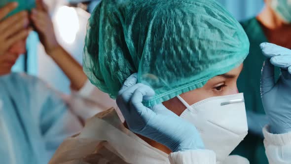 Female doctor putting on a medical cap, protective mask KN95, glasses and hazmat