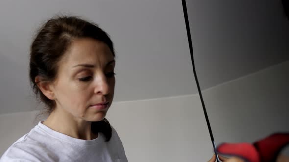 Portrait of young woman is smiling while wiping the tv screen