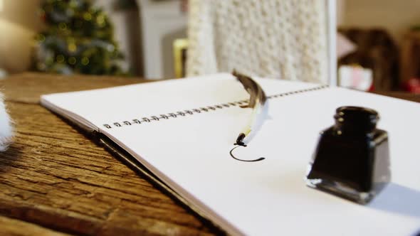 Close-up of diary with ink bottle and quill