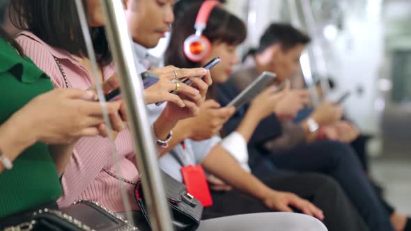 Young People Using Mobile Phone in Public Underground Train