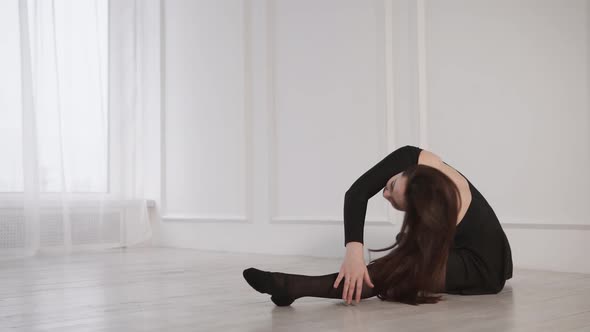 Young Brunette Woman Is Doing Exercises for Stretching Legs and Back