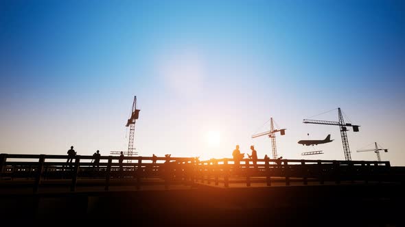 Construction Worker Looking At Blueprints With Sunset alt