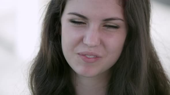 Tight shot of a teenage girl eating and smiling.