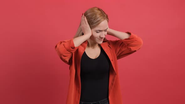 Close Up of a Confused Woman Holding Her Hands To Her Ears and Nodding