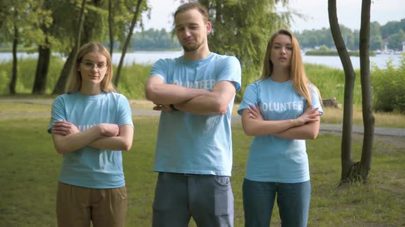 Group of Confident Man and Women in Volunteer T-shirts Posing in Sunlight After Cleaning Summer Park