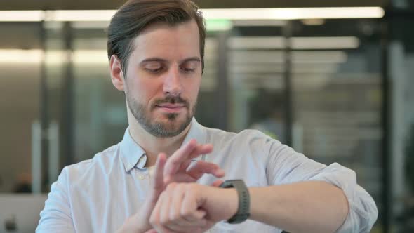 Portrait of Mature Adult Man Using Smartwatch