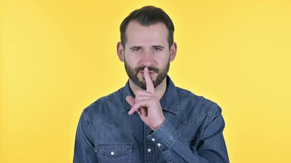 Beard Young Man Putting Finger on Lips, Yellow Background