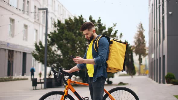 The Food Delivery Guy is Standing and Texting