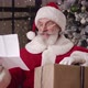 Charming Kind Santa Claus Holds a New Year's Gift Box Nods His Head Directing His Gaze From the - VideoHive Item for Sale