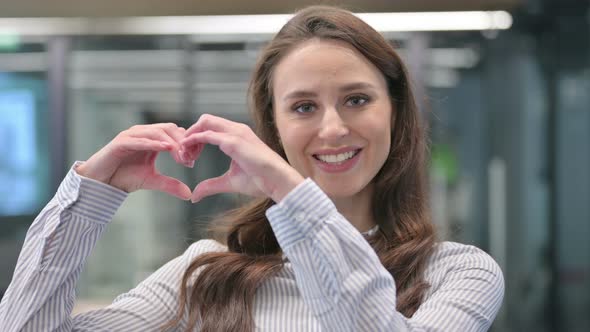 Portrait of Young Woman showing Heart Shape by Hands