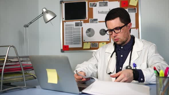 Medical Assistant Working at Workplace with Notebook and Medical Forms.