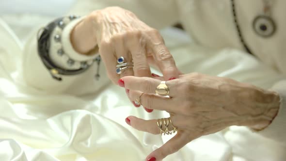 Old Woman Putting on Ring on Finger.