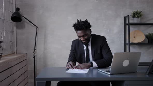 Business Man African American Makes Paper Airplane and Launches It in Office