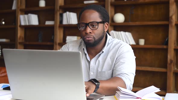 Young African American Male Employee Using a Laptop