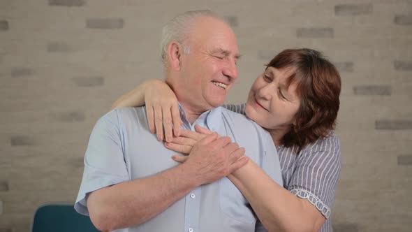 Cheerful Senior Adult Family Couple Hugging, Laughing, Looking at Camera.