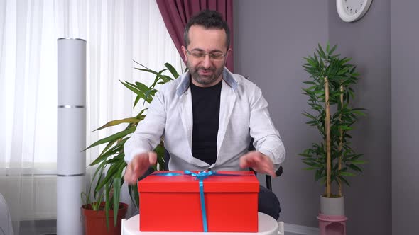 Man opening gift wrap, joy.