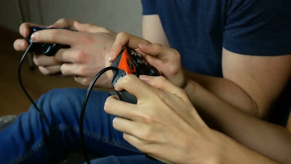 Young People Play On The Console And Use The Gamepad