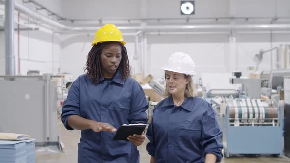 Diverse Female Factory Colleagues in Helmets