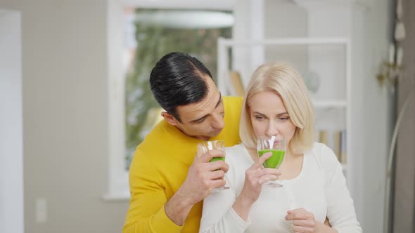 Portrait of Young Couple Smelling Healthful Green Smoothie and Making Disgust Facial Expression