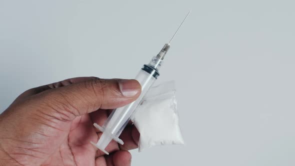 Hand Holding Heroin And Needle