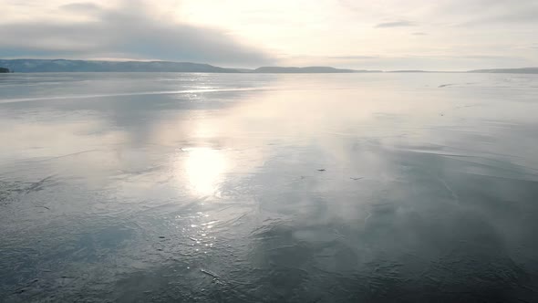 It's an Aerial View. The Winter Landscape of the Freezing River. The Ice Reflects the Sky and the