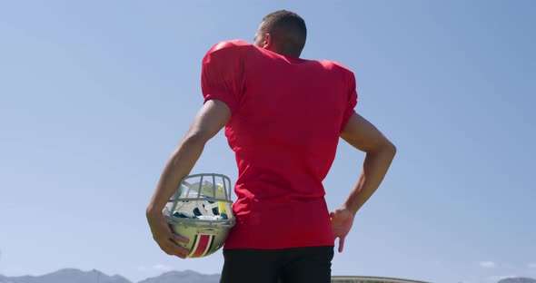 American football player standing with helmet