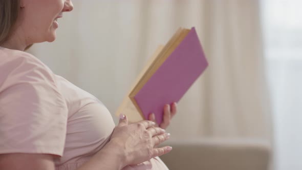 Expectant Woman Reading Book To Belly