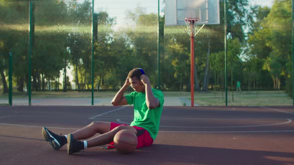 Streetball Player Listening Music on Outdoor Court