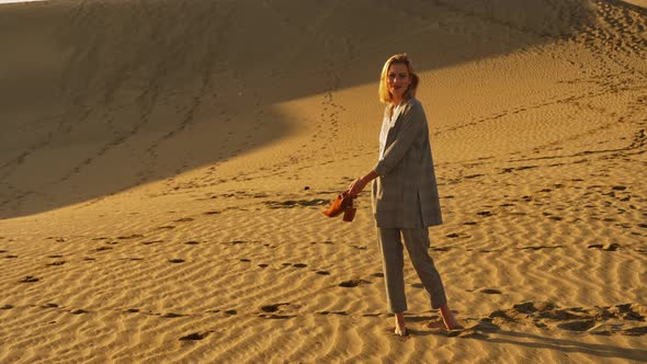 Attractive Woman in Business Attire Twirling in the Sand Dunes