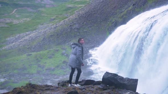 Man Watching Fast-flowing Water Of Dynjandi Waterfall In Arnarfjordur In Westfjords of Iceland.