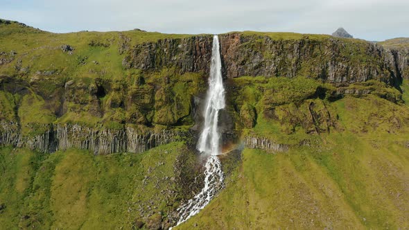 Aerial Drone Footage of Bjarnarfoss Waterfall with Its Green Cliffs in Western Iceland