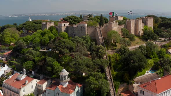 Drone Camera Flying Towards Stone Castle on Top of Hill Over Town