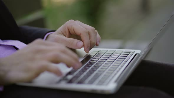 Male Hands Typing on Keyboard of Laptop