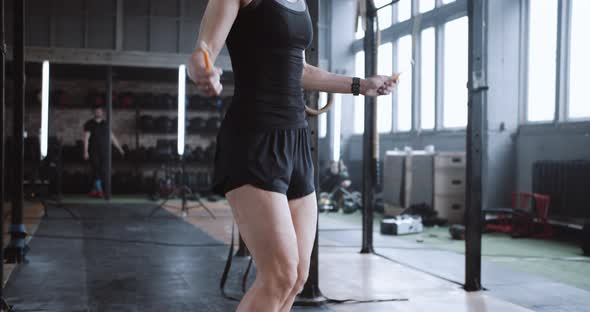 Closeup Young Beautiful Blonde Woman Exercising with Jump Rope Working Out in Large Atmospheric Gym