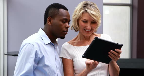 Executives discussing over digital tablet