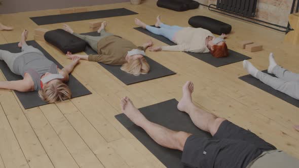 Seniors Meditating on Floor with Eye Pillows