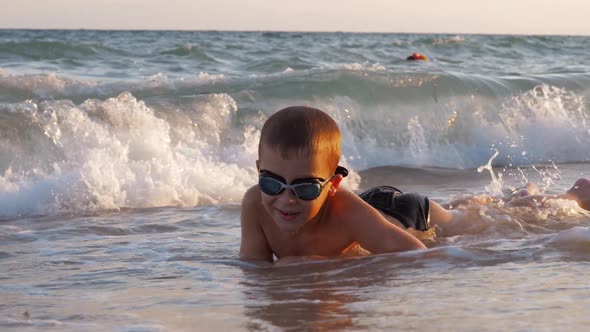 Child Is Excited with Sea Waves Covering Him