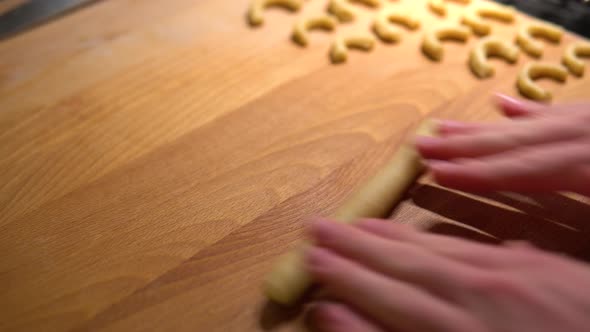 A Close Up View of a Man's Hands As He Cuts and Kneads Raw Cookie Dough.