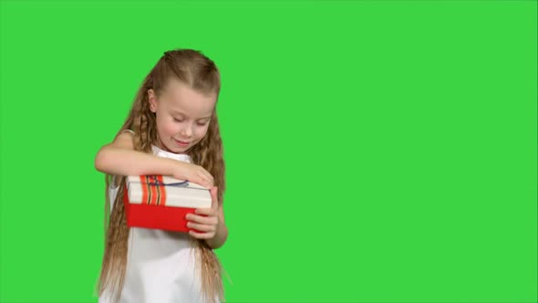 Happy Smiling Girl Holding Gift Box on a Green Screen, Chroma Key