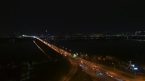 A Police Car with a Siren on is Moving Along a Night Highway in the City