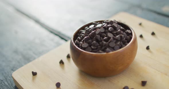 Video of close up of bowl with organic chocolate chip on wooden background