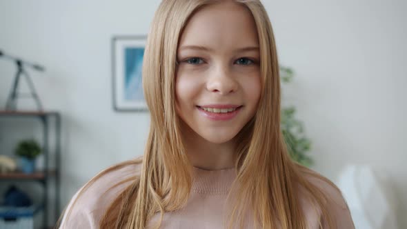 Portrait of Beautiful Child with Blond Hair Standing Indoors in Apartment Smiling Looking at Camera