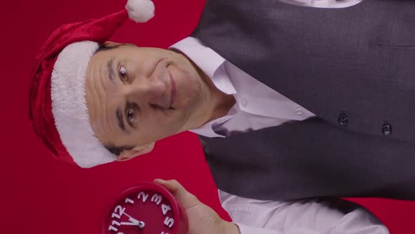 Vertical Shot Cheerful Man in Santa Hat Pointing at Clock Reminds Minutes Before New Year Eve