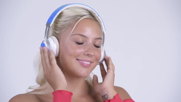 Face of Happy Young Beautiful Blonde Woman Listening To Music